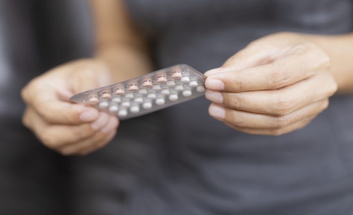 Midsection Of Woman Holding Blister Pack